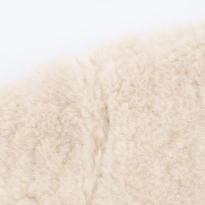 Macro shot of high-density cream white curly faux fur fabric with soft fluffy texture