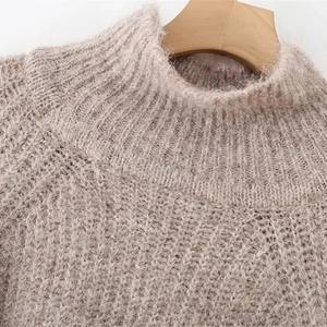 Beige turtleneck knit sweater in mohair blend with soft fluffy texture on a wooden hanger