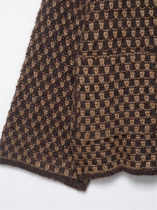 Detailed close-up of brown textured knit sweater showing premium jacquard pattern weave