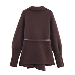 Detail view of the back of a dark brown knitted cardigan with leather belt and lantern sleeves