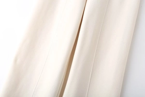 Detailed view of vertical stitched seams on cream-colored fabric with smooth texture