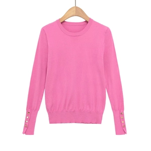 Pink slim-fit knit sweater with round neck and gold decorative buttons on cuffs