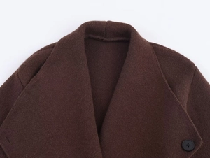 Detailed close-up of dark brown knit cardigan lapel and matte black button texture