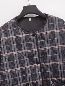 Detail of diamond quilted plaid jacket with round neck, black binding and XS size label
