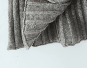 Detailed macro shot of grey ribbed knit cardigan cuffs showing premium fabric texture