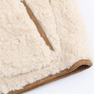Detailed macro of beige faux shearling texture with brown corduroy piping trim