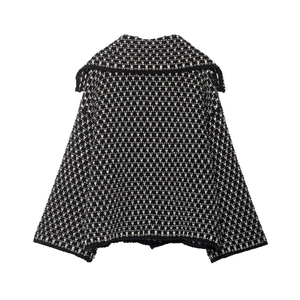 Detail of knit jacket with black and white geometric texture and wide lapel collar