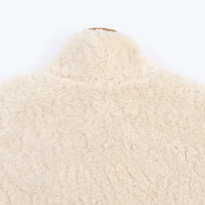 Close-up of soft cream faux fur texture and precise stitching on a warm fleece jacket