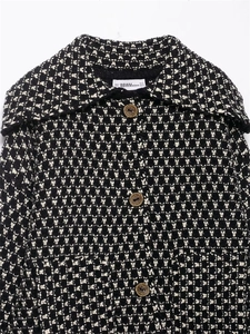 Detailed close-up of knit texture and buttons on monochrome geometric cardigan