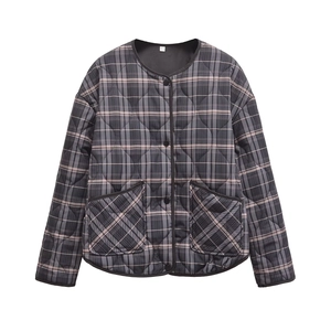Detail of quilted plaid jacket with round neck, large pockets, and black button closure