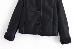 Détail d'une veste noire en suédine avec garniture en fausse fourrure au col et aux poignets