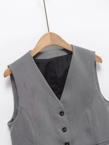 Detail of grey V-neck vest featuring single-breasted resin buttons and smooth lining