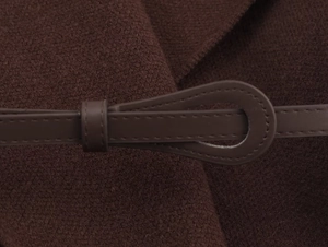 Detailed close-up of dark brown knit cardigan with unique teardrop belt loop design