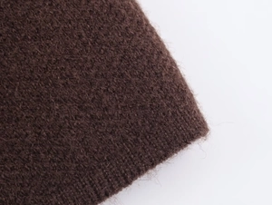 Close-up of deep brown knit fabric texture with soft wool fibers and warm material detail