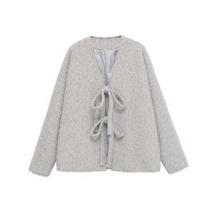 Detail of light grey faux fur jacket with V-neckline and elegant ribbon bow tie closures