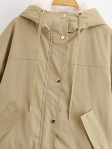 Detalle de parka caqui con capucha con ribete de piel sintética y botones dorados
