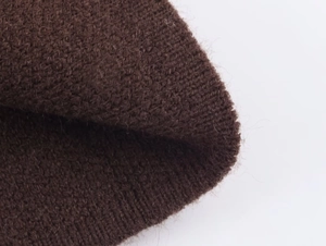 Macro shot of dark brown knitted fabric showing dense texture and ribbed elastic edges