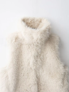 Close-up of cream faux fur vest showing high stand collar and plush texture detail
