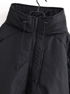 Détail de veste d'hiver noire à capuche avec cordon de serrage et poche poitrine zippée