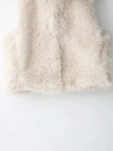Close-up of thick light beige faux fur texture on sleeveless vest with soft fibers