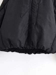 Détails d'une doudoune noire coupe-vent avec ourlet élastique à cordon et poches zippées