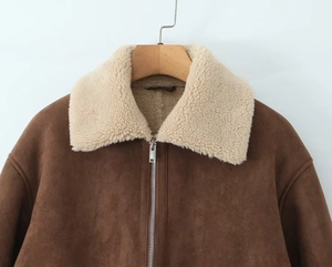 Détail de la veste en suédine marron avec col en polaire blanche et fermeture éclair