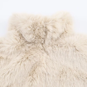 Close-up of soft faux fur texture on a cream stand collar jacket with plush details