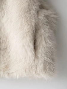 Macro shot of high-quality cream faux fur texture on a stand-collar sleeveless vest