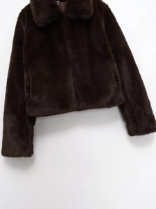 Gros plan sur la texture en fausse fourrure marron foncé et la doublure de la veste