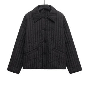 Detail of black quilted jacket featuring lapel collar and vertical stitching pattern
