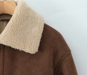 Détail de la veste en daim montrant les coutures de qualité et le col en peau d'agneau