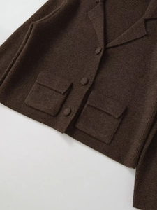 Dettaglio del cardigan in maglia marrone scuro con colletto a rever e trama