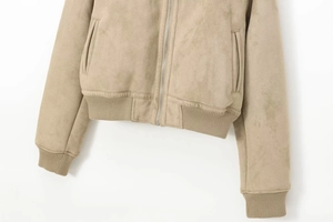 Detalle de chaqueta de ante sintético caqui con dobladillo acanalado y cremallera
