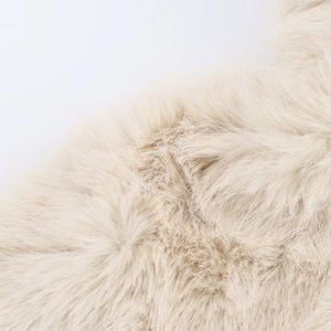 Macro texture of soft cream faux fur material on women's winter jacket with fluffy fibers