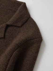 Dettaglio di maglione marrone in maglia con trama in lana e cuciture del colletto