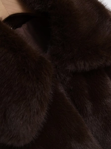 Gros plan sur la texture dense et le lustre d'une veste en fausse fourrure marron