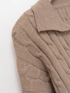 Close-up of oatmeal knit sweater showing thick cable knit texture and classic polo collar