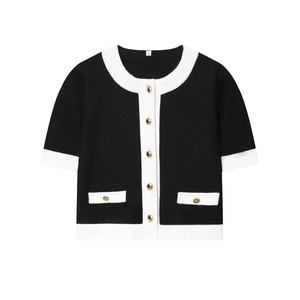 Détail d'un cardigan noir chic en tricot avec bordure blanche et boutons dorés