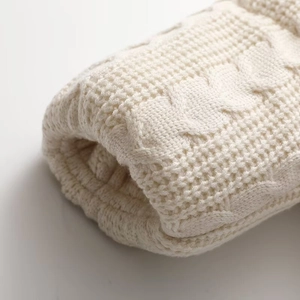 Macro detail of French style cable knit texture on a cream white winter cotton jacket