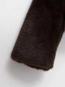 Vue détaillée de la texture de fourrure synthétique marron foncé et du revers de la veste