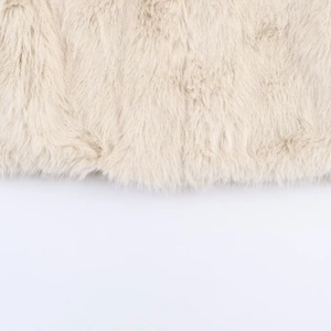 Detail shot of the plush cream faux fur fabric with dense and soft hair texture