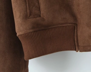 Gros plan détaillé de la veste en daim marron foncé avec ourlet côtelé et coutures fines