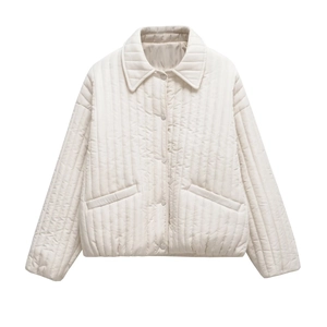 Detail of cream quilted jacket featuring unique heart-shaped buttons and vertical stitching