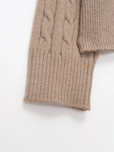 Close-up of cable knit texture and ribbed cuff on this soft tan knitted sweater