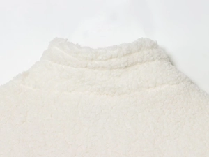 Detailed close-up of cream-white sherpa fleece texture on a stand-up collar jacket