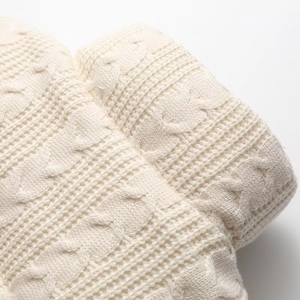 Detailed view of cream cable-knit and waffle texture on this autumn jacket fabric