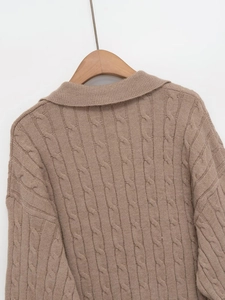 Close-up of camel cable knit texture and turn-down collar on long sleeve sweater