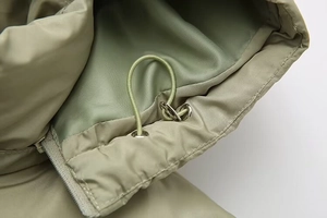 Macro detail of hooded cotton jacket showing elastic drawstring and metal cord locks