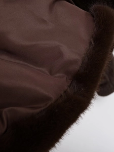 Vue détaillée du tissu marron foncé avec bordure en fausse fourrure douce de qualité