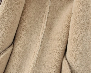 Gros plan sur la doublure en laine d'agneau beige et le zip du blouson de baseball